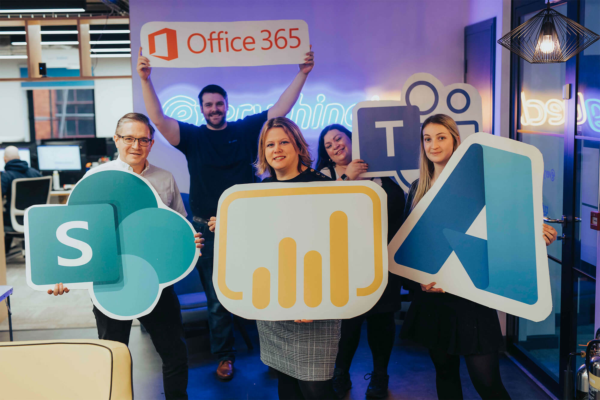 everything tech staff members holding up logos for office 365, teams, SharePoint, power bi, & azure